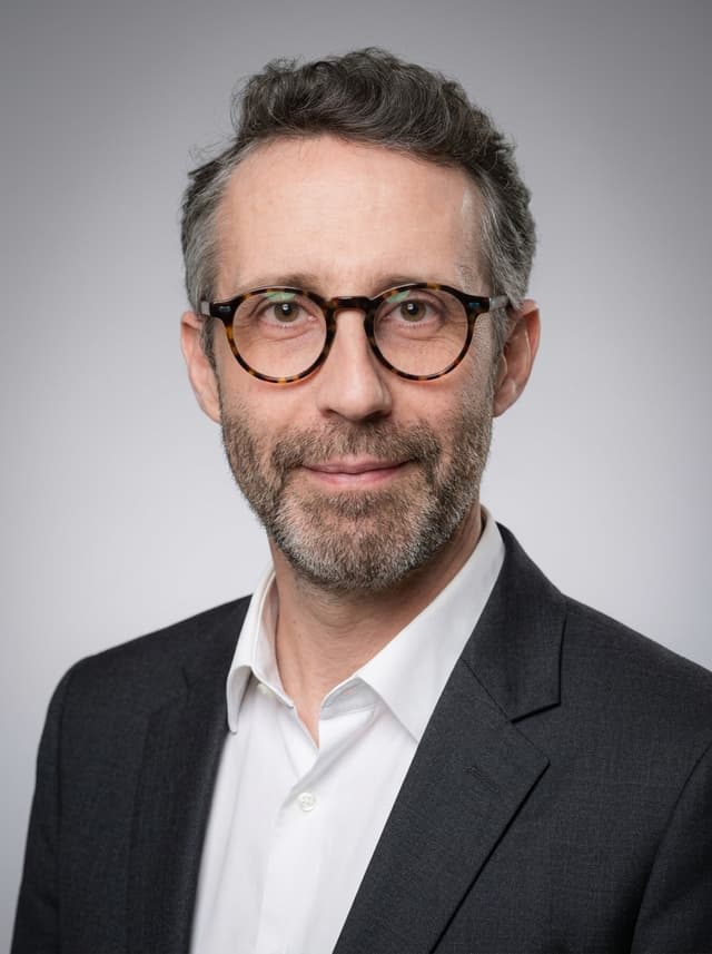 Portrait professionnel style Corporate Classique : fond gris neutre, cadrage buste, blazer sombre